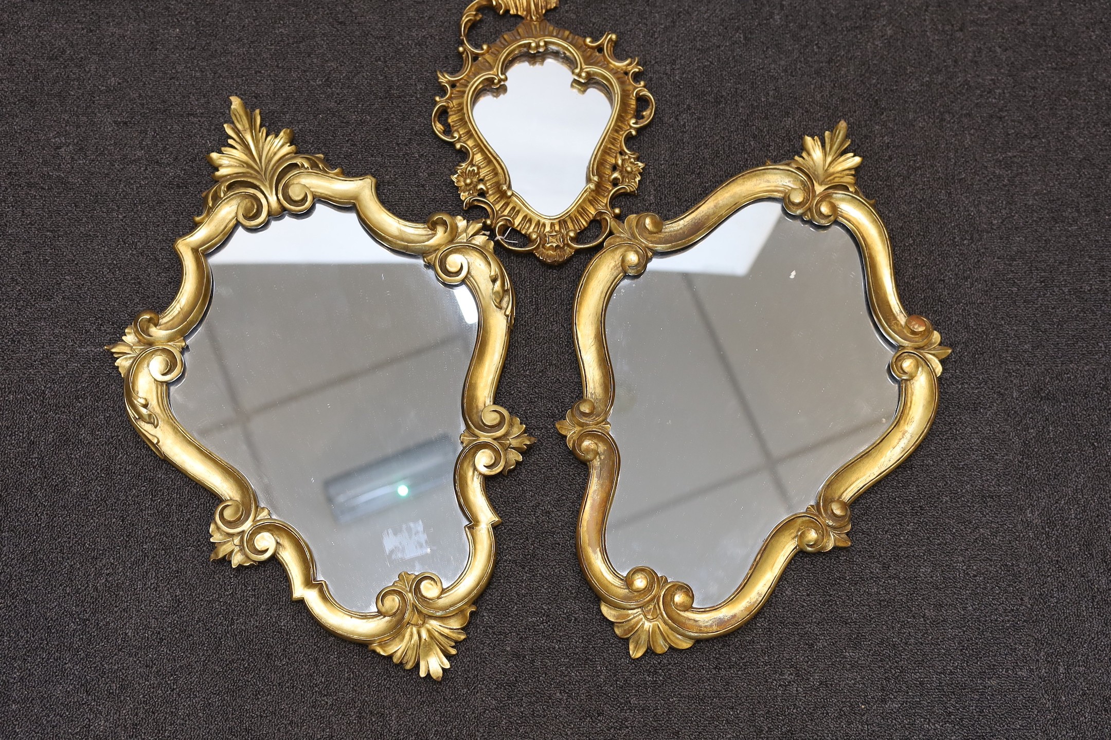 A pair of George III style giltwood cartouche wall mirrors, height 60cm, together with two similar smaller cartouche wall mirrors